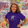 Lisa Martinez, principal at Columbine Elementary and PCDP alumna smiling in front of student art