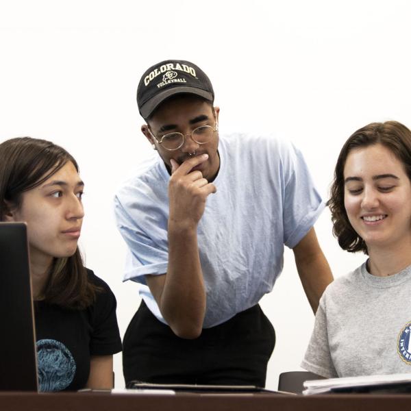 Nathaniel Nash helps two students with their advertising projects.