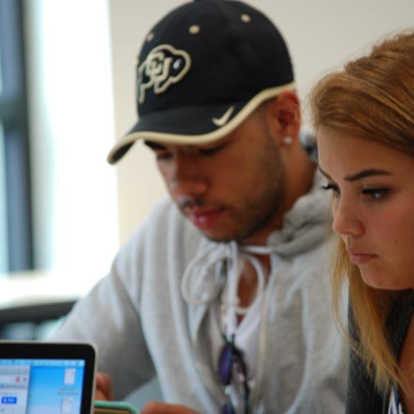 Darrion Pyos and Kayla Williams work on a story. (Photo by Murray Meetze/University of Colorado)