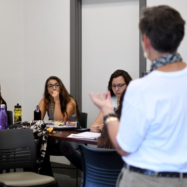 Lauren Smith, Olivia Leddy and Olivia Miller listen to Ruth Hickerson during a communications session.