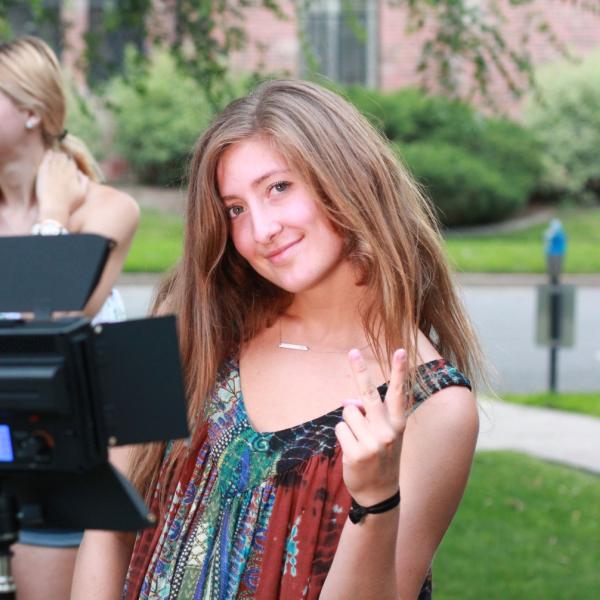 Katie Pickrell poses after setting up light stand during Broadcast I session