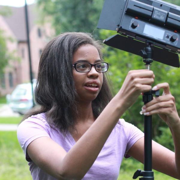 Jacqueline Lee sets up light stand during Broadcast I session