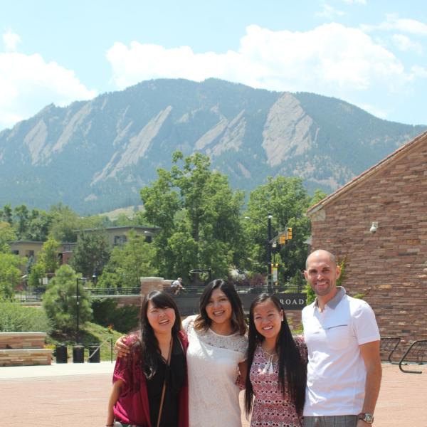 Group members pose for a picture in front of the Flatirons