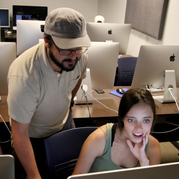 Instructor Eric Coombs helps Lauren Irwin set up her project.