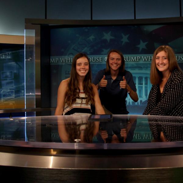 Lauren Irwin and two of her peer mentors, Conner Davis and Katie Pickrell, pose for a photo at the CBS news desk.