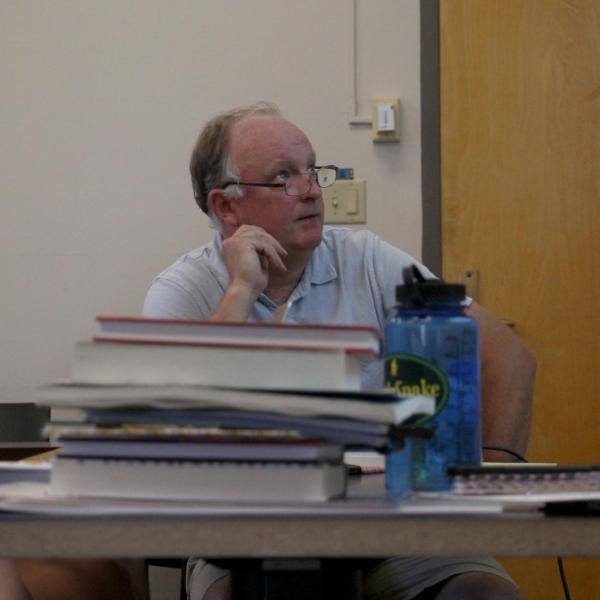 Professor Michael Stoner looks over a project with two students.
