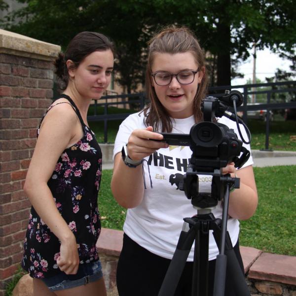 Bella Liffick and Emma Baziuk look over their footage.