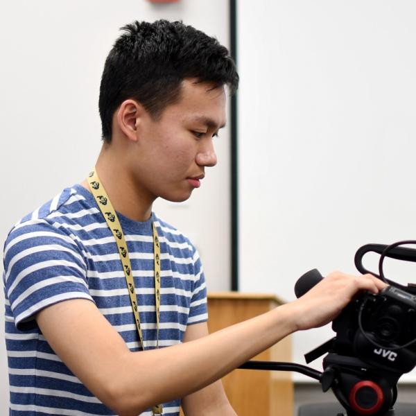 Ian Lee sets up a camera to interview one of his classmates.