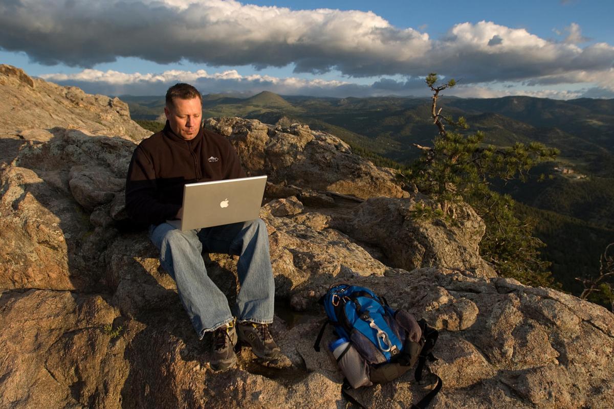 Man on mountain with laptop