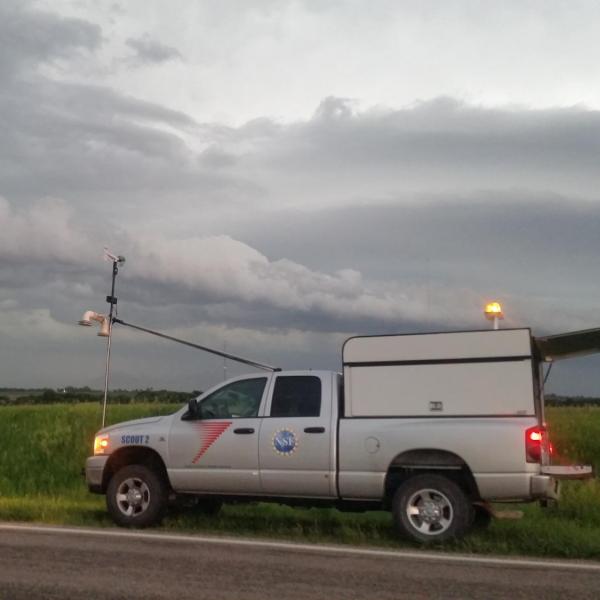 A Center for Severe Weather Research (CSWR) scout vehicle instrumented with weather instruments waiting for a mesoscale convective system (MCS) to move over its location during the PECAN field project on 10 June 2015.