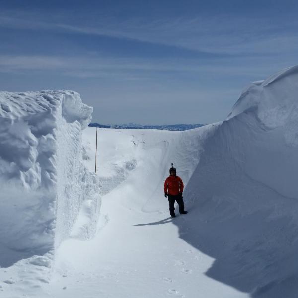 CU graduate student Josh Aikins surrounded by snow drifts at the Snowbank mountaintop location (8,000 ft elevation) in central Idaho on 12 March 2017, a site used during the SNOWIE field project to study the impacts of cloud seeding on mountain snowpack between January - March 2017.