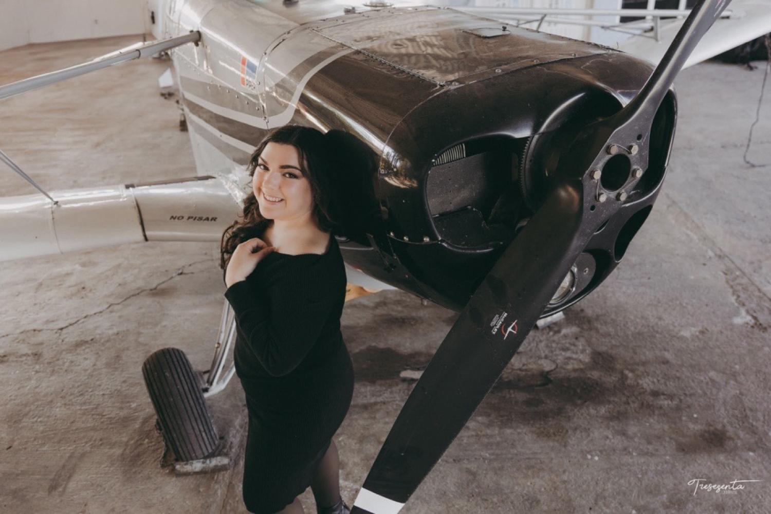 Ruby Gomez Martinez stands next to a propeller plane
