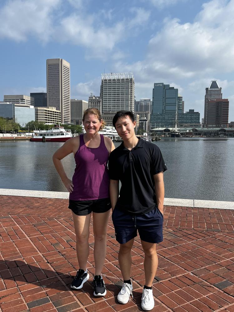 Robert Wang and Mindy Zarske in front of buildings and water in Baltimore