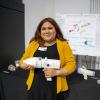 Medina-Lopez holds her group's capstone project, a hand-held plume evacation device