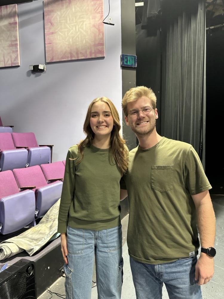 Collin wearing a green shirt standing next to another person