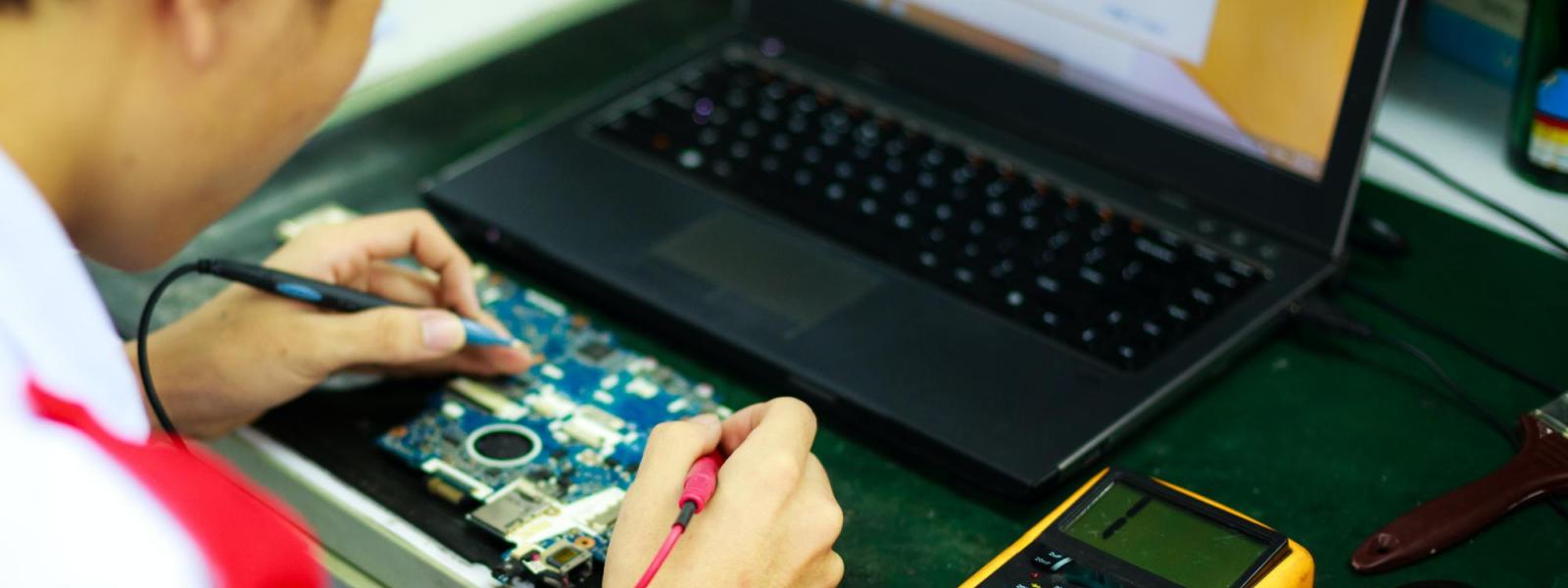 a young man using a multimeter