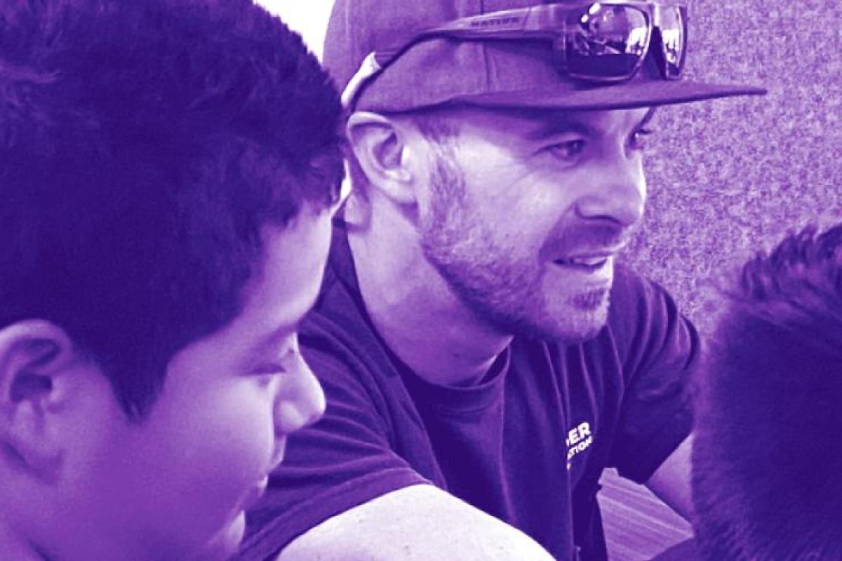 Mentor and two youth looking at a project together