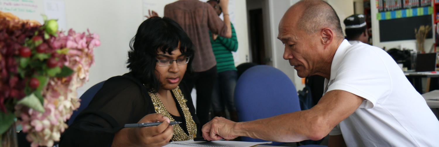A woman and a man working together on a writing assignment