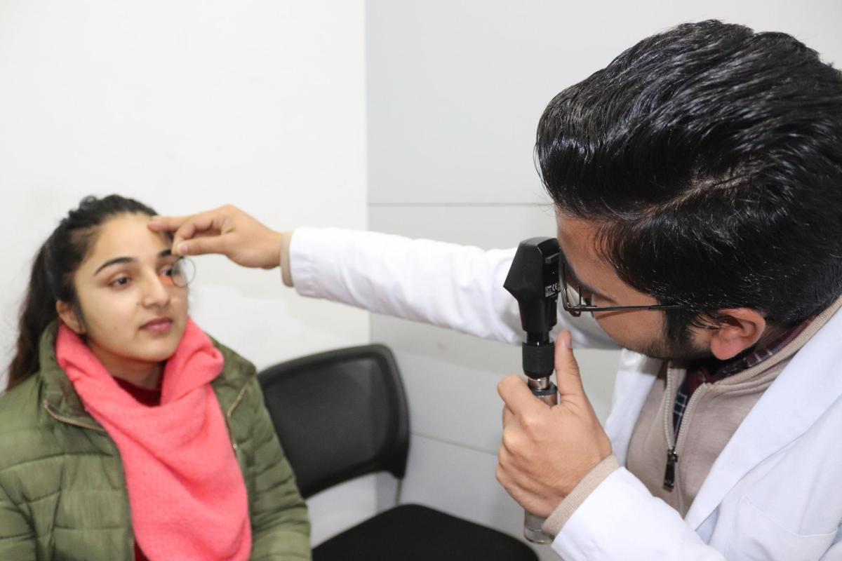 An optometrist examines a patient's eye.