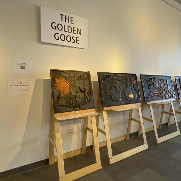 Story panels on easels showing images from The Golden Goose fairy tale.