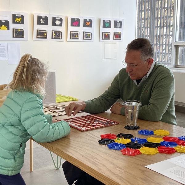 Girl and grandfather playing tactile version of Othello.