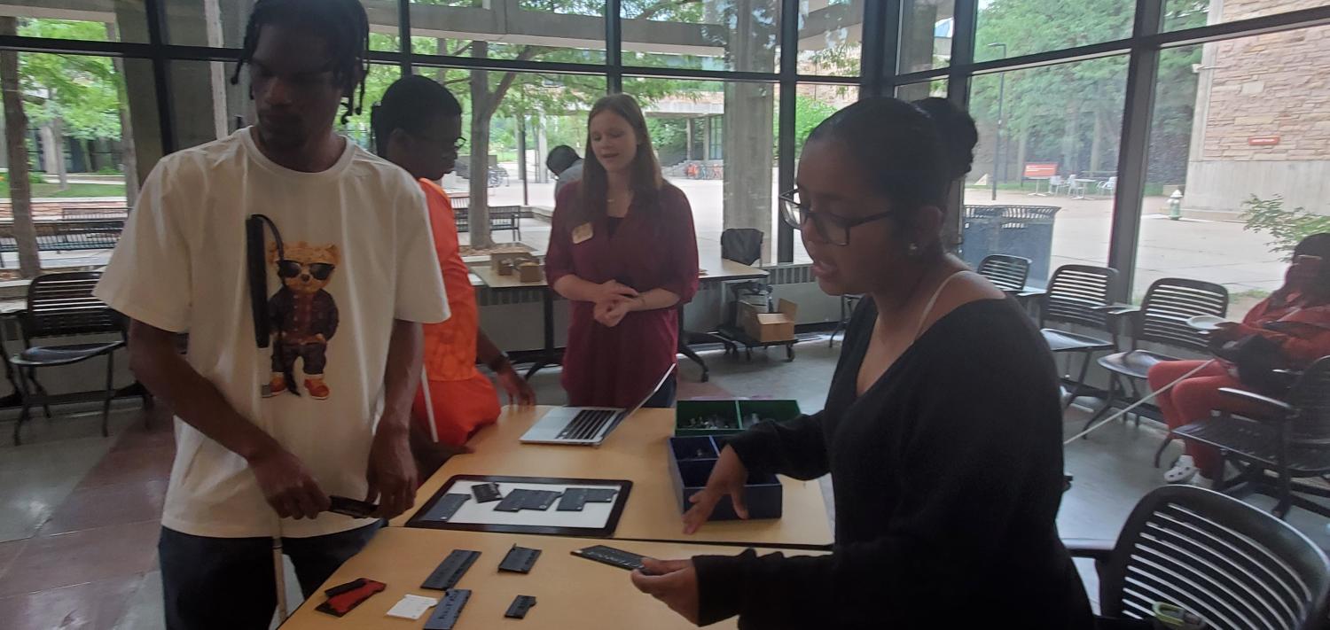 people around a table with accessible coding tools
