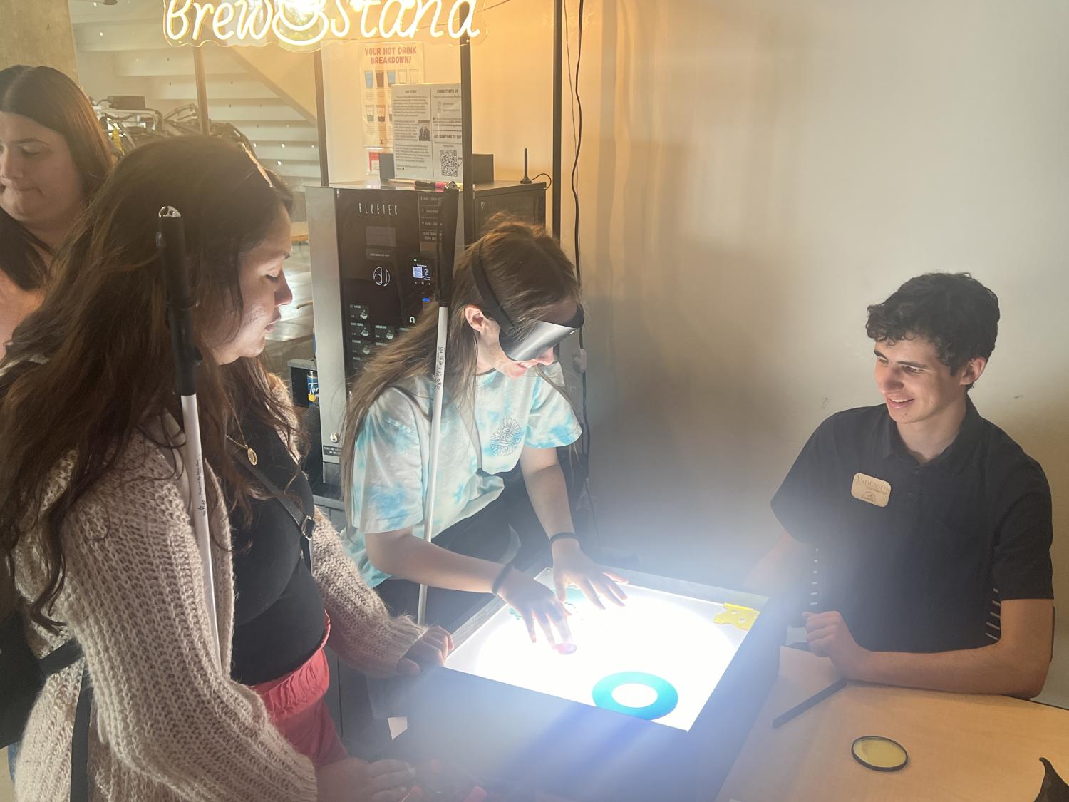 3 people around a lite brite