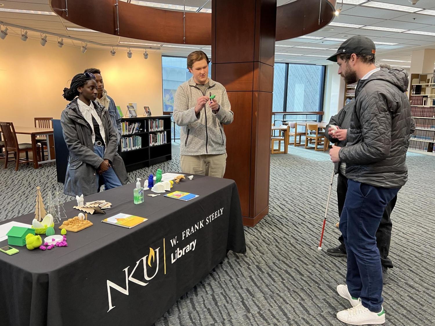 Blind and sighted students talking at a table.