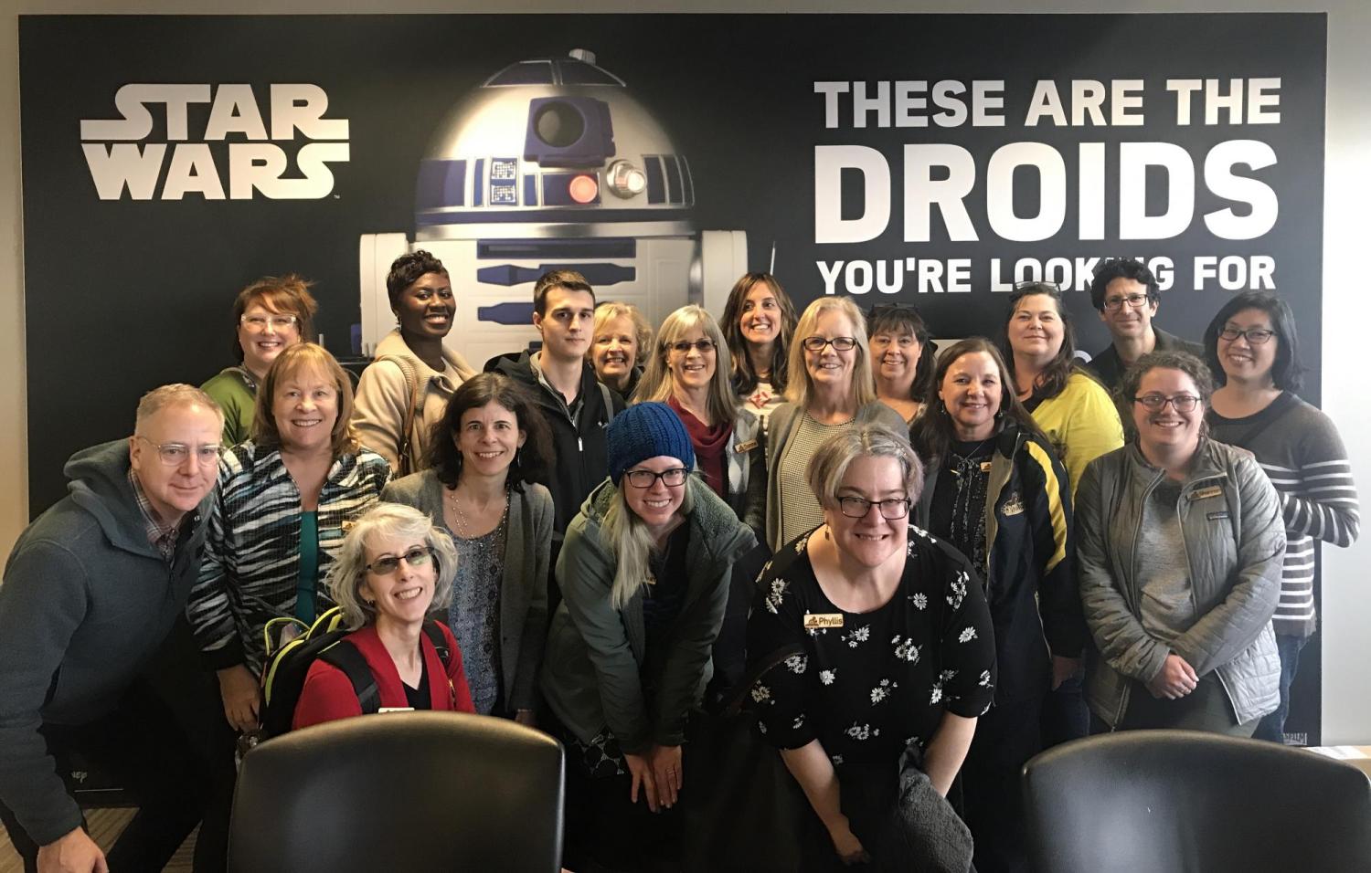 Attendees for Professional Development posing in front of a Star Wars poster.