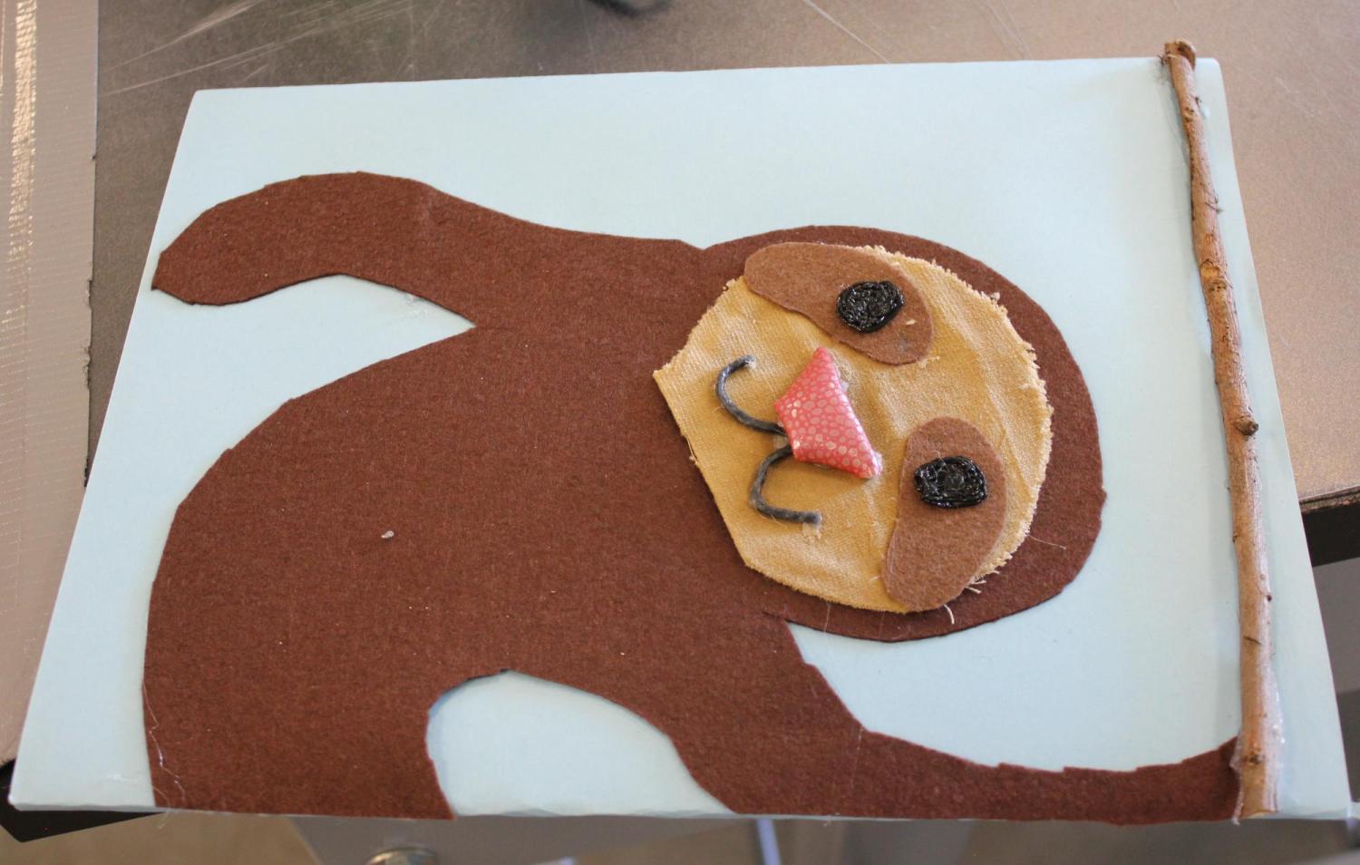 Tactile image of a sloth made with felt, fabric, and wax shapes