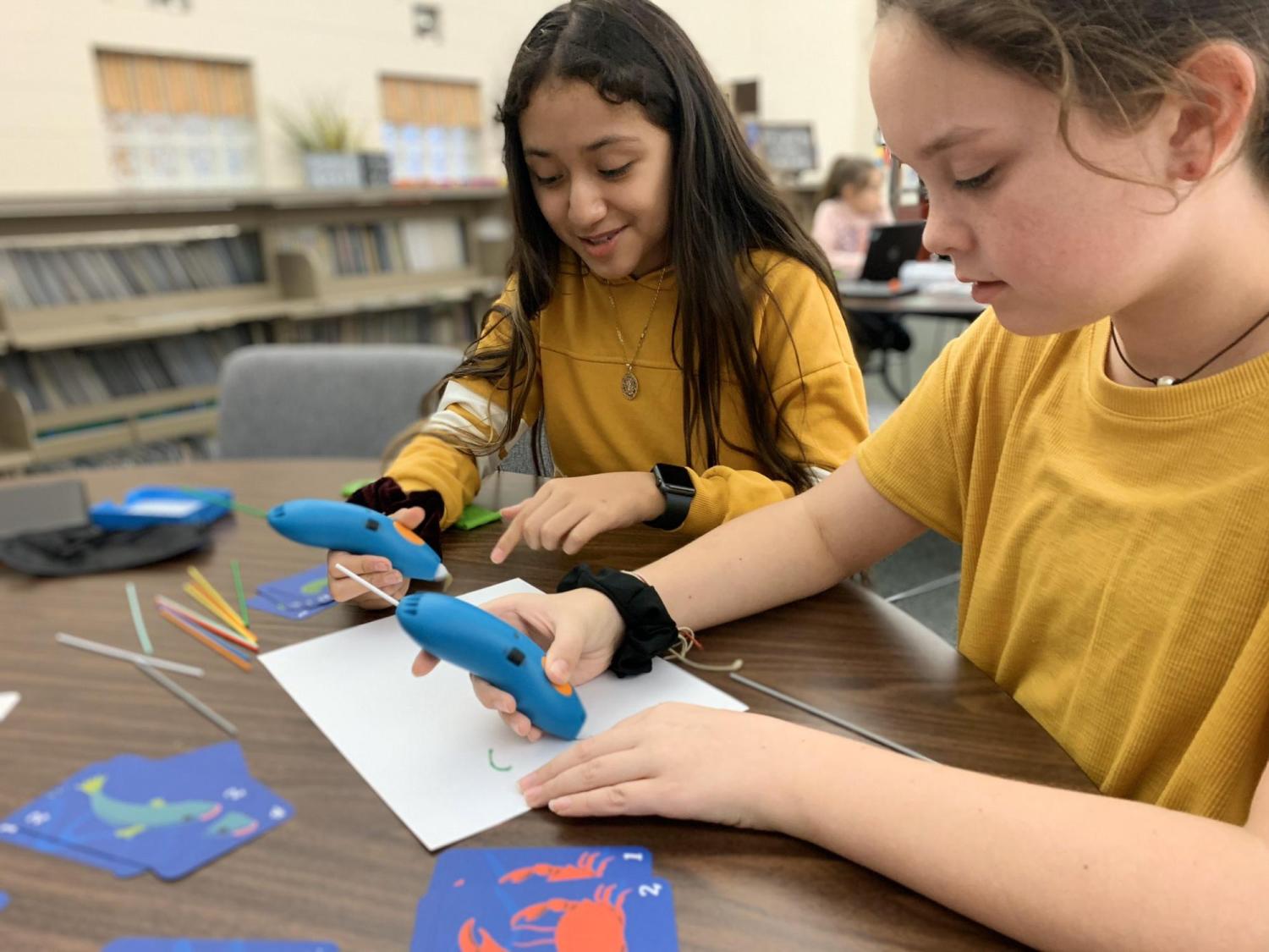 Two students working with 3D printing pens