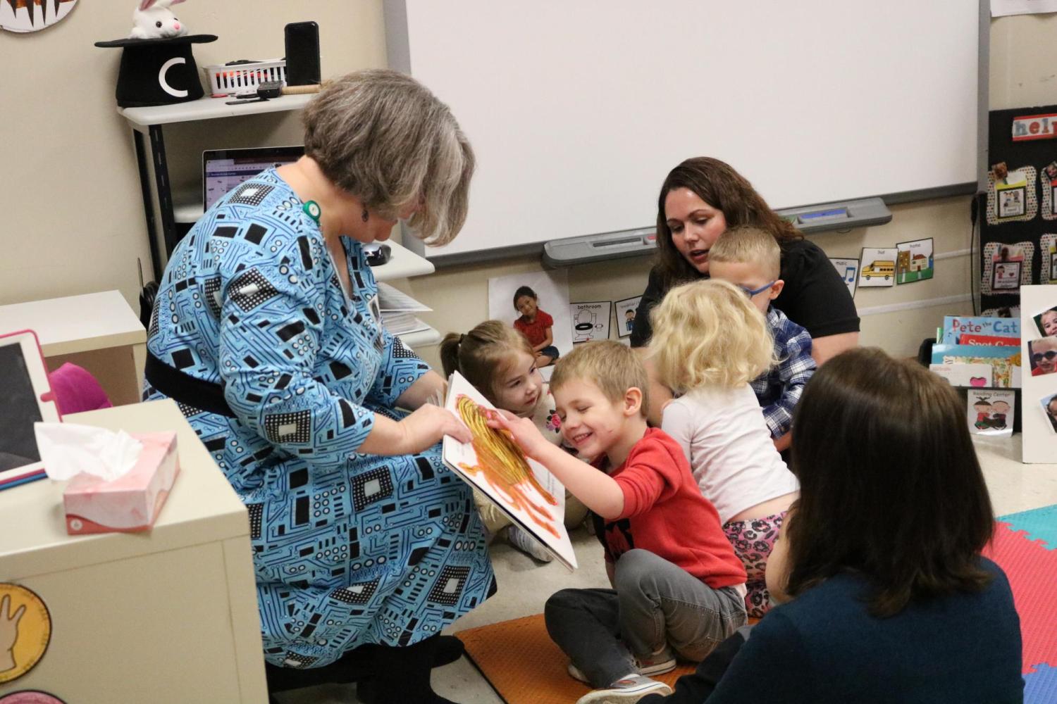Librarian sharing tactile boardbook with preschool students