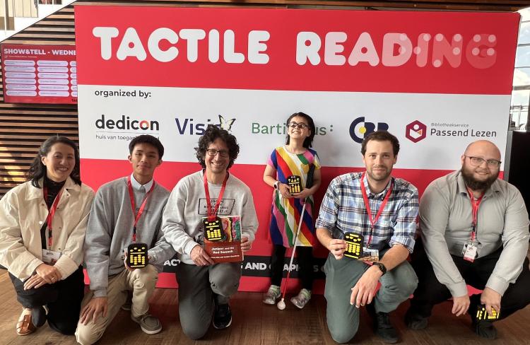 A group of people in front of a sign