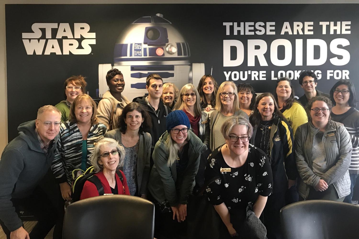 Workshop attendees posing in front of a Star Wars poster
