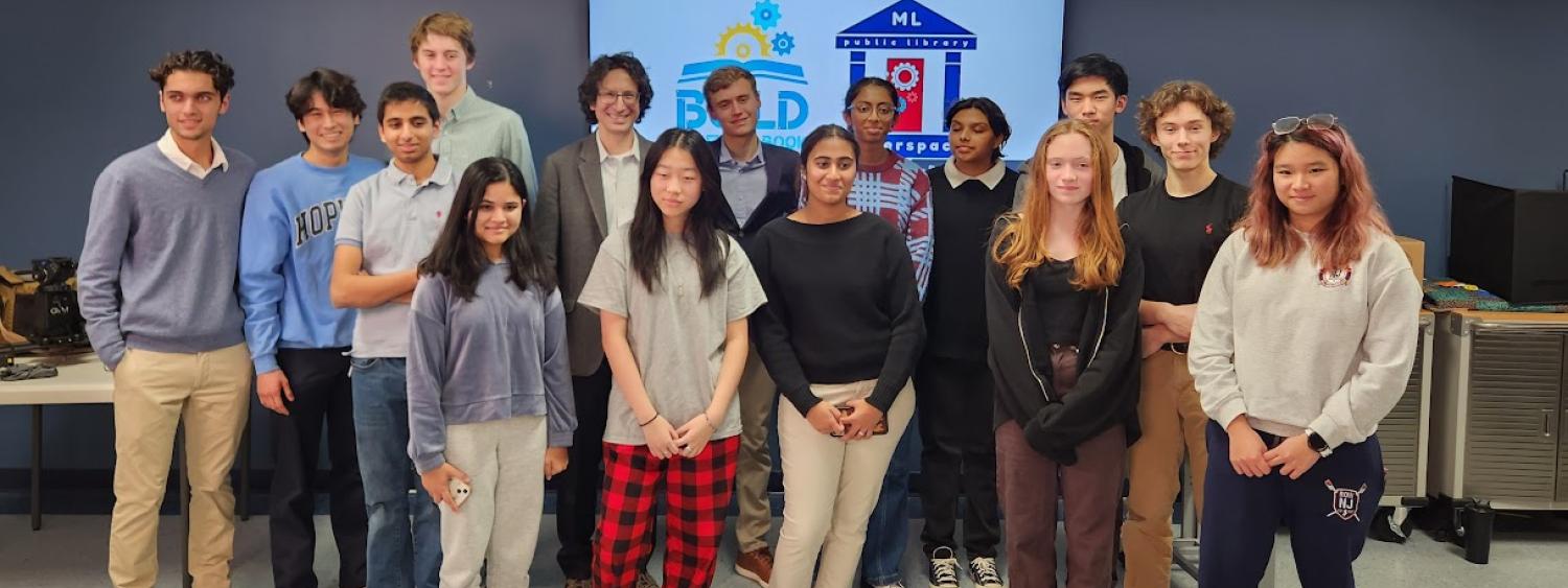 Teen interns standing in a group after presenting their projects.