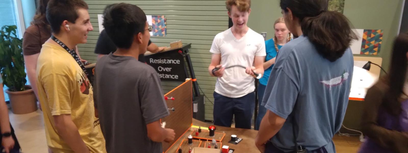 A teen explaining his project to others