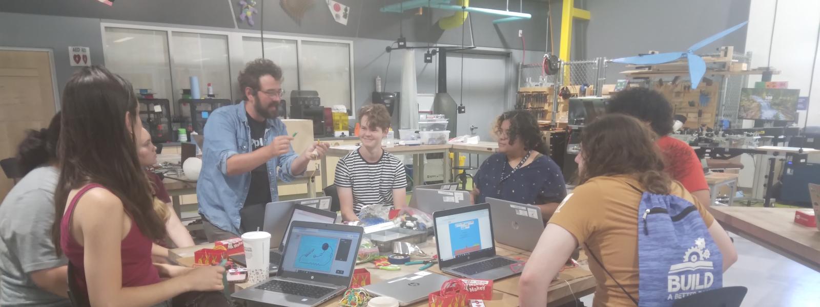 group of NM Explora Interns gathered around a table