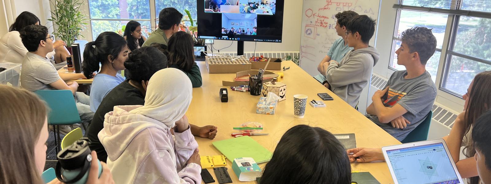 A group of teens looking at a TV