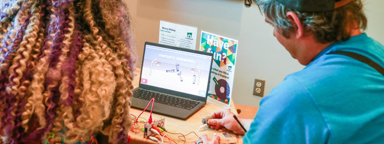 2 people working with circuits and a computer