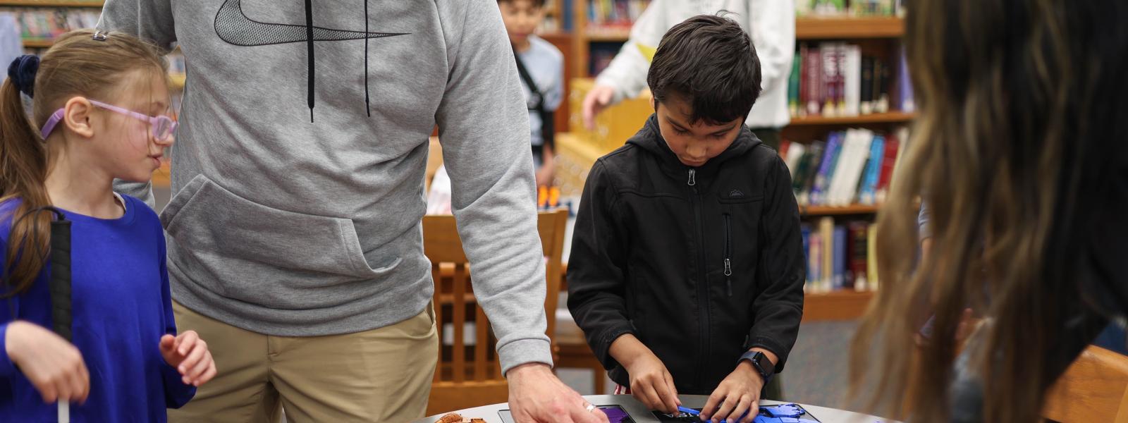 a group of people looking at item on a table
