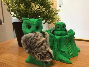 3D printouts of a mother owl, baby owl, and tree stump.
