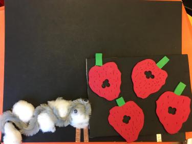 Pipecleaner caterpillar and foam strawberries mounted on board with copper tape circuit.