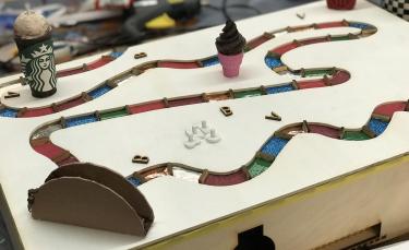 Board for the sports game showing winding path with textured spaces and fast food icons.