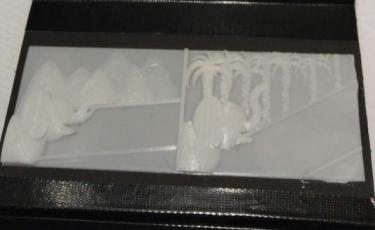 3d printed page showing a baby elephant with some trees and black book binding