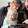 A blind child explores a tactile book with her fingers.