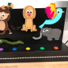 Black box with felt and 3D printed animals of a monkey, dog, bird, snake, and elephant.