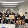 Group of people holding up tactile pictures of birds