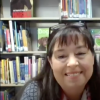 Rachel Brockman sitting in front of library bookshelves.