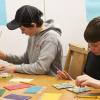 Two boys working on creating tactile memory game pieces.