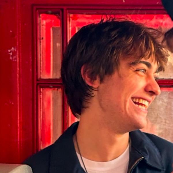 Man laughing in front of a red door